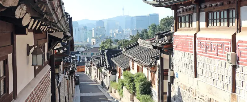 ruelle de maisons traditionnelles de Bukchon, les tours de Séoul en arrière-plan